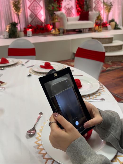 Guest using a phone inside a Notography case at a formal event